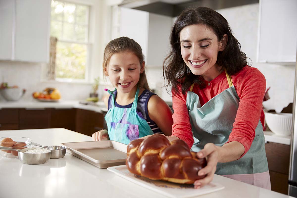 Mother and daughter with baked challah bread.